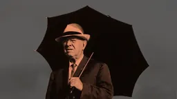 Pau Casals in a hat under an umbrella, image for Pau Casals a Puerto Rico at the Museu de la Música