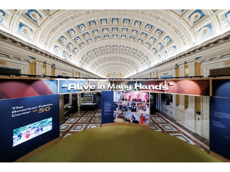 The welcome wall of "Alive in Many Hands" at the Library of Congress, made of enlarged photos of people practising folk traditions woven together like a basket