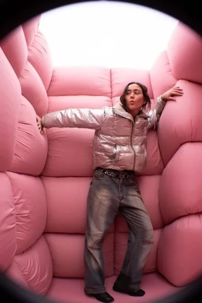 Visitant recolzada a l’interior d’una sala encoixinada de color rosa suau, de Dreams, d’Andres Reisinger, al Moco Museum Amsterdam
