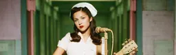Olivia Rodrigo, vêtue d’une robe et d’une coiffe de style infirmière vintage, tient une guitare près d’un microphone dans un couloir vert