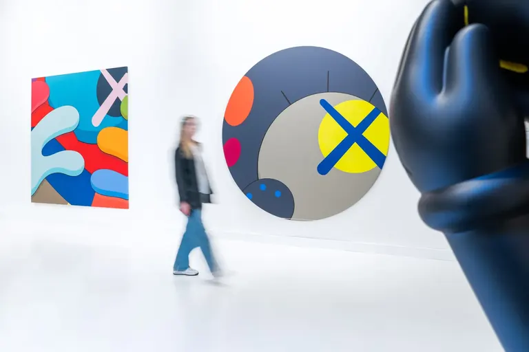 زوار أمام أعمال KAWS الفنية في Moco Museum Barcelona