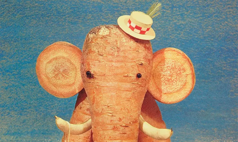 A sculpture composed of carrots and decorative materials, arranged in the form of an elephant