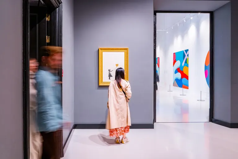 زوار أمام أعمال Banksy في Moco Museum Barcelona