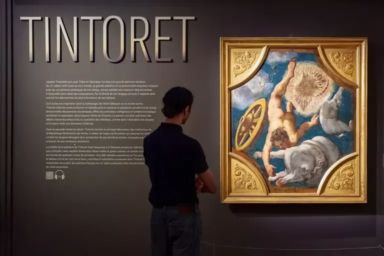 一名參觀者站在 Musée Jacquemart-André「Timeless Tintoretto」展覽首個展廳內，欣賞一幅丁托列托的天花畫