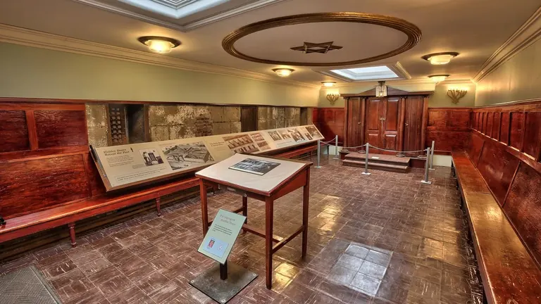 Synagoge im Eastern State Penitentiary mit Holzvertäfelung und Bänken, einem Tisch in der Mitte, einem Toraschrein und einer Decke mit Davidstern.