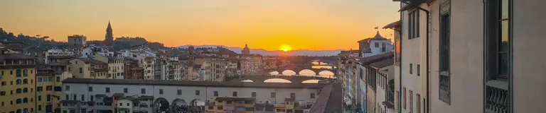Vista del perfil urbà de Florència al capvespre, amb el Ponte Vecchio il·luminat sobre el riu Arno, des del recorregut del Vasari Corridor