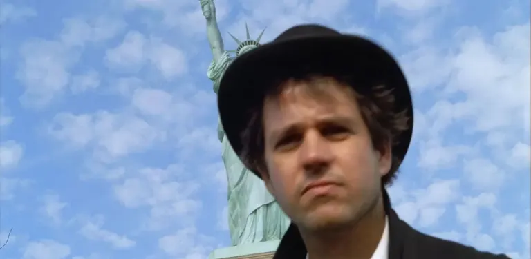 Film still from Deutschland versenken, 1999: Christoph Schlingensief in front of the Statue of Liberty