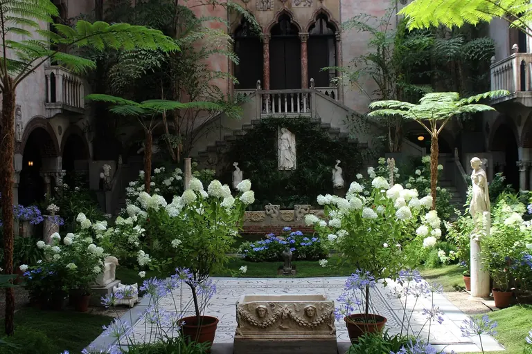 Looking across the planted courtyard of the Isabella Stewart Gardner Museum toward its arched Venetian balconies