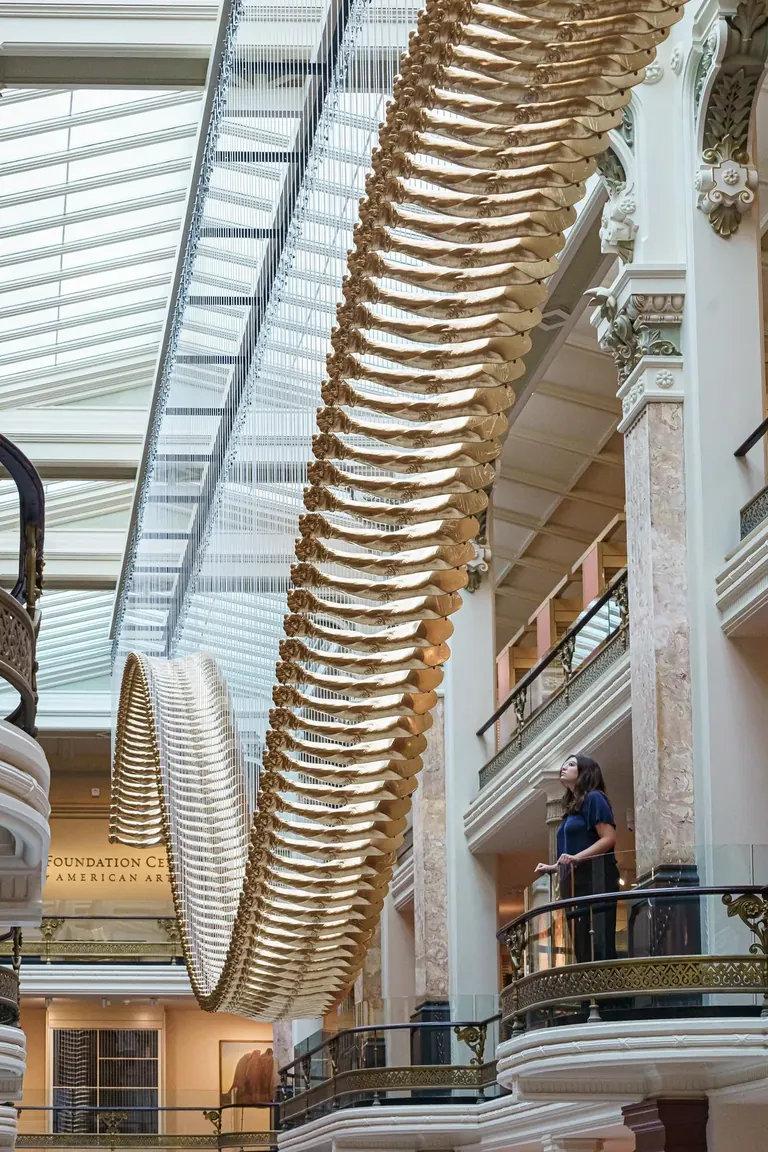 Glenn Kaino's Bridge, an aerial sculpture of 200 gold-cast arms suspended in the Luce Foundation Center