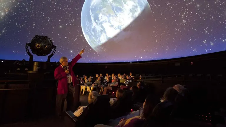 Audience seated beneath the dome of the Charles Hayden Planetarium during a show