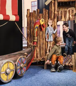 Une famille joue dans le village viking de Viking Life avec Halvdan et Meia