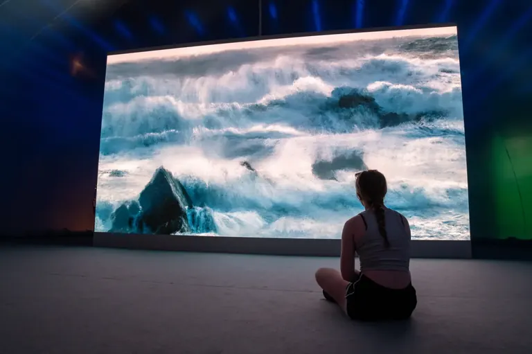 Visitor watching a large-scale digital artwork in Vectors at Disseny Hub Barcelona