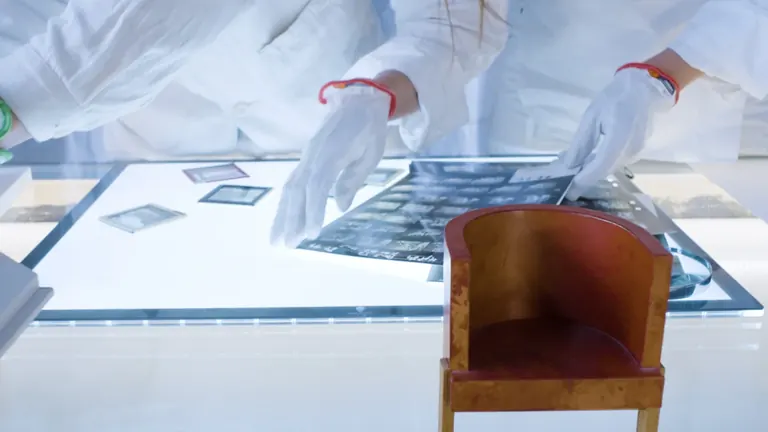 Une conservatrice d’ArkDes déballant des dessins d’archives dans la salle Unboxing