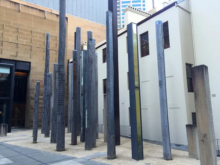 The Edge of the Trees installation of timber and sandstone pillars in the Museum of Sydney forecourt