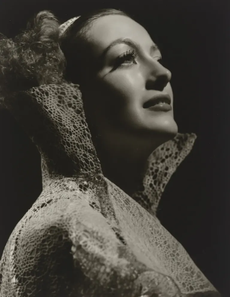 Black-and-white George Hurrell portrait of Joan Crawford, chin lifted, in dramatic studio lighting