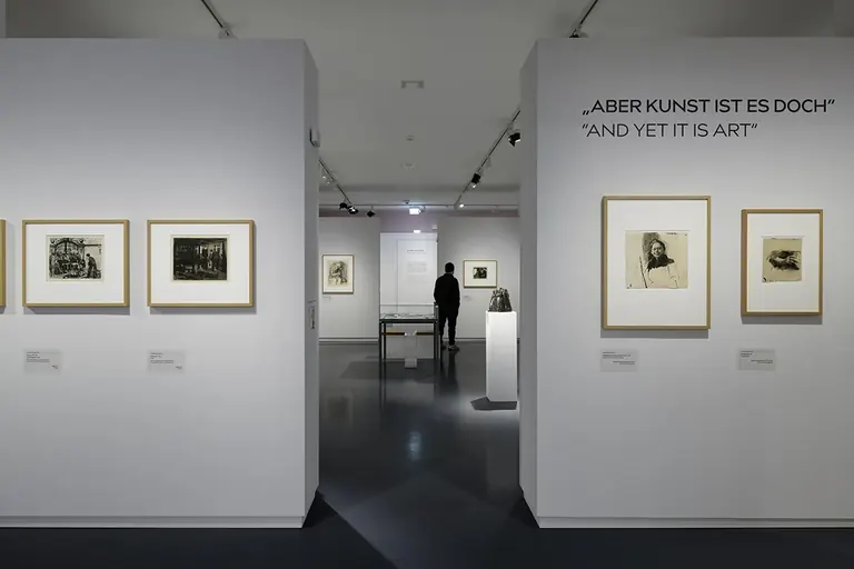 Installation view of Käthe Kollwitz – And yet it is art, with framed prints and the exhibition title on the gallery wall