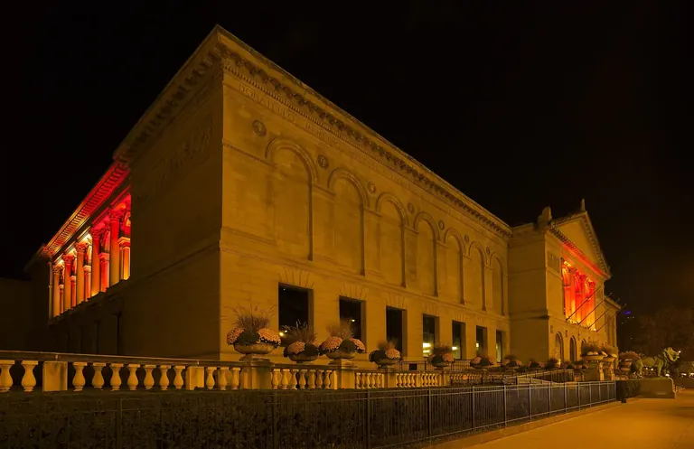 La façade Beaux-Arts de l’Art Institute of Chicago, sur Michigan Avenue, illuminée la nuit, avec l’un de ses lions en bronze à droite