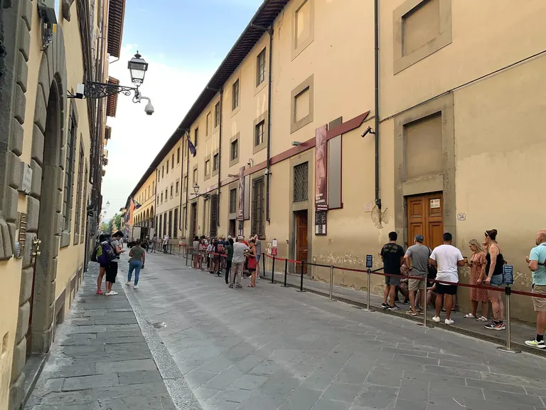 The Galleria dell'Accademia building on Via Ricasoli, Florence, with the visitor queue along its facade