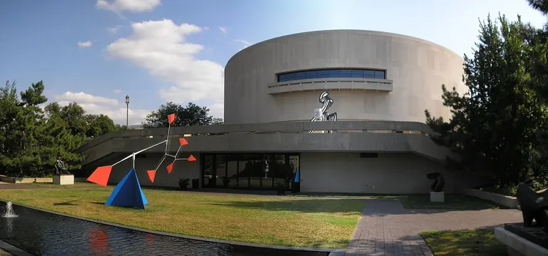 The cylindrical concrete exterior of the Hirshhorn Museum, raised on four piers, on the National Mall in Washington, DC