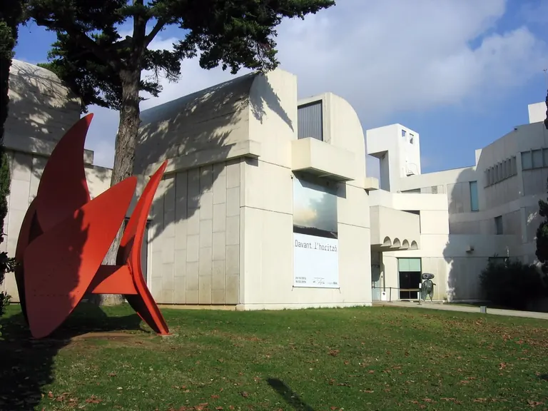Exterior of the Fundació Joan Miró's white Josep Lluís Sert building on Montjuïc, with a red sculpture on the lawn