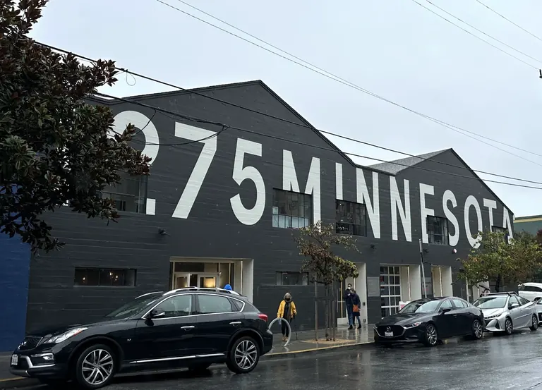 Façade d’entrepôt gris anthracite du Minnesota Street Project, avec l’inscription « 1275 Minnesota » peinte en grandes lettres blanches
