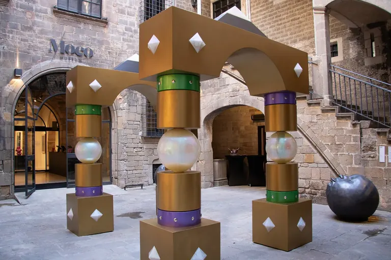 The Gothic courtyard of the Palau Cervelló, home of Moco Museum Barcelona, with the Moco sign above the entrance