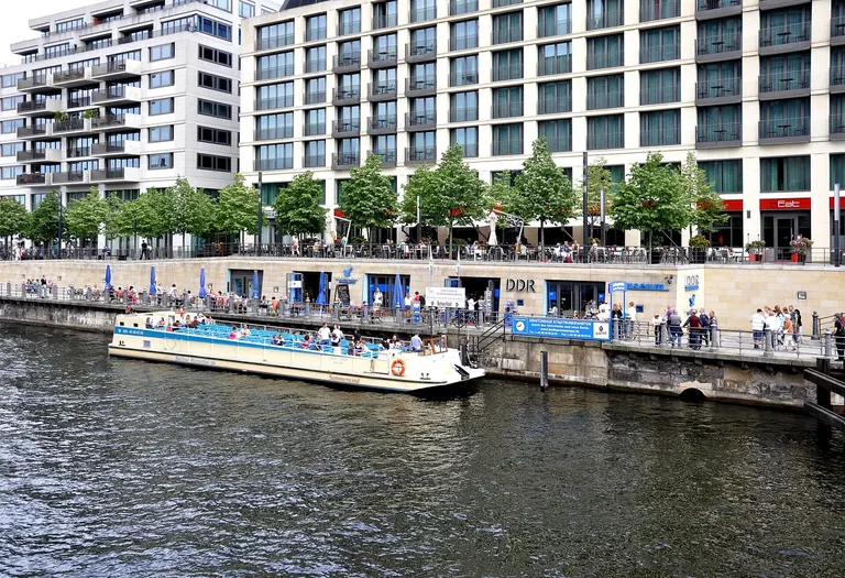 Entrance of the DDR Museum on the Spree promenade in Berlin-Mitte, with a tour boat moored in front