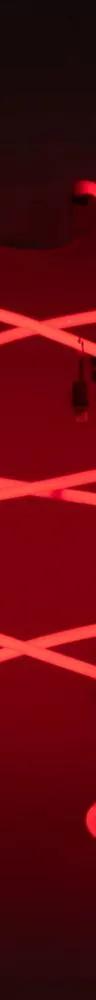 A glowing red neon light sculpture forms looping geometric curves against a dark background