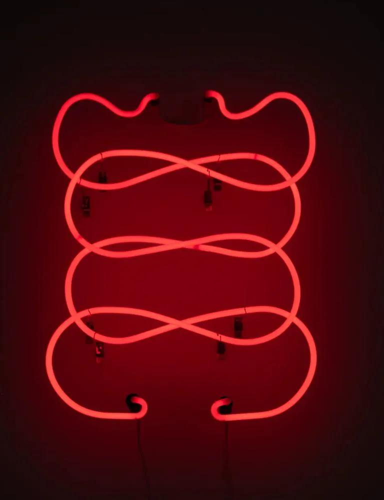A glowing red neon light sculpture forms looping geometric curves against a dark background