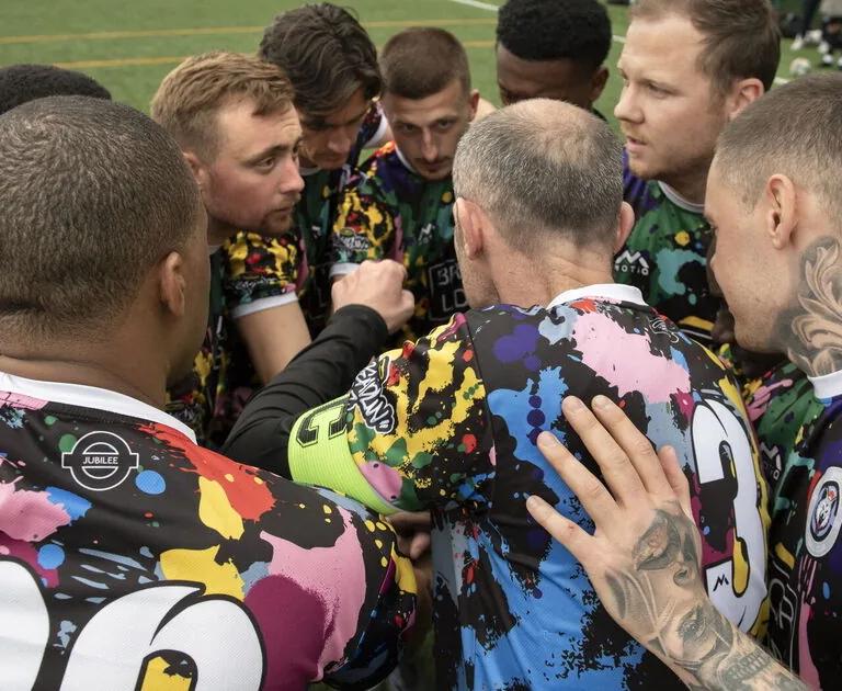 A group of footballers gather in a circle