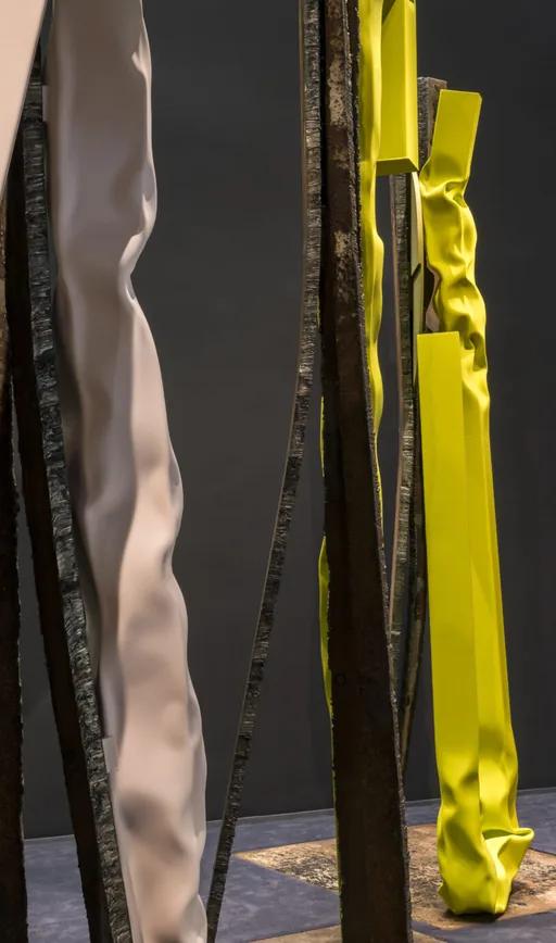 Brightly colored steel sculptures by Carol Bove in the Guggenheim's gallery, with a visitor looking up at the forms