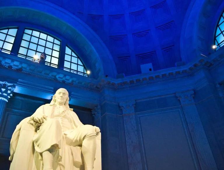Benjamin Franklin Memorial statue with dramatic dark blue lighting
