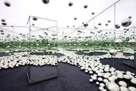 Interior of Yayoi Kusama's mirrored installation with silver orbs