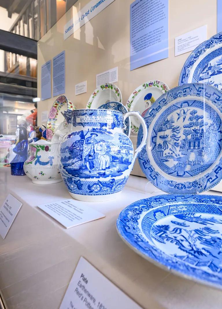 A collection of blue and white plates elegantly displayed in a glass case, highlighting their intricate designs