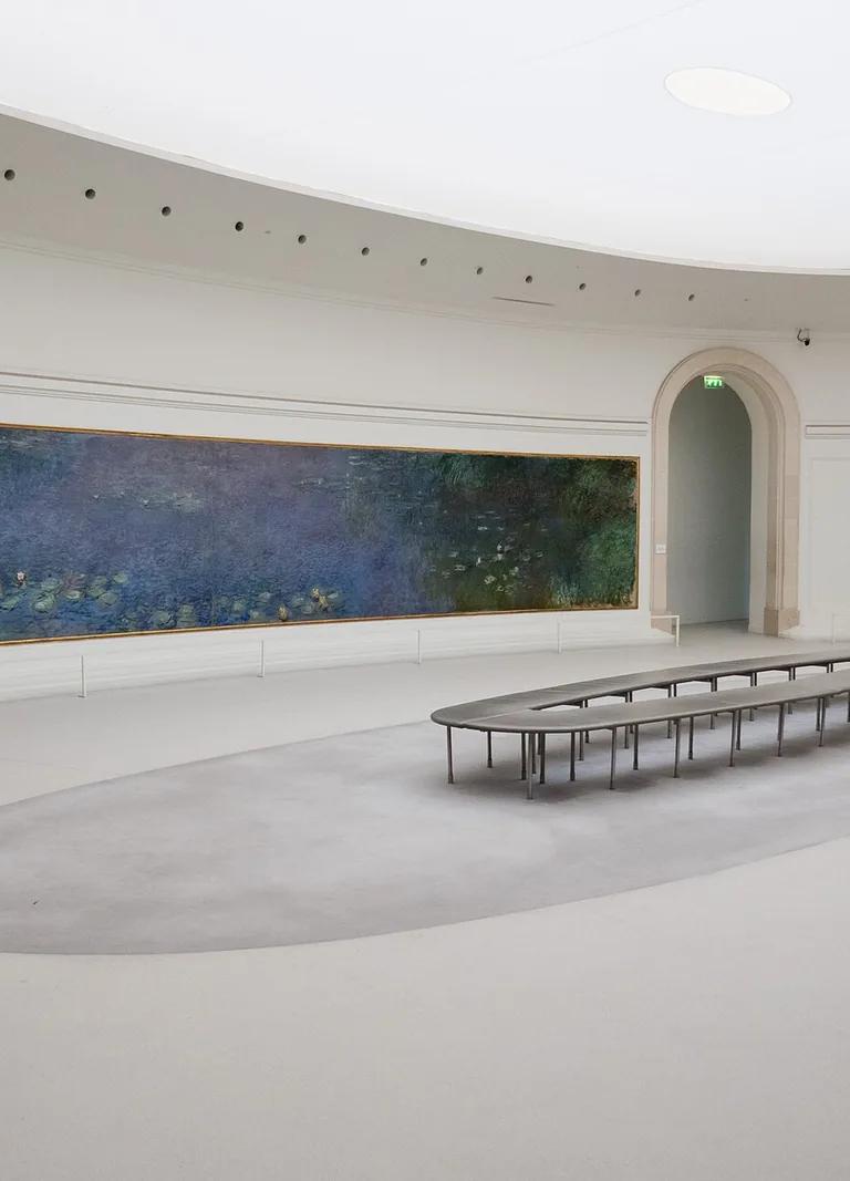 Claude Monet's Water Lilies displayed in an oval room at the Musée de l'Orangerie