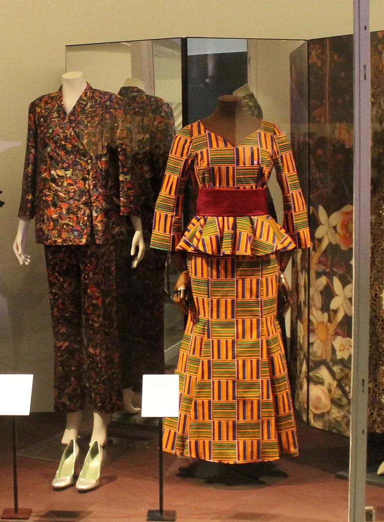 A glass display case with historic dresses and outfits in the Fashion Gallery at the Victoria and Albert Museum