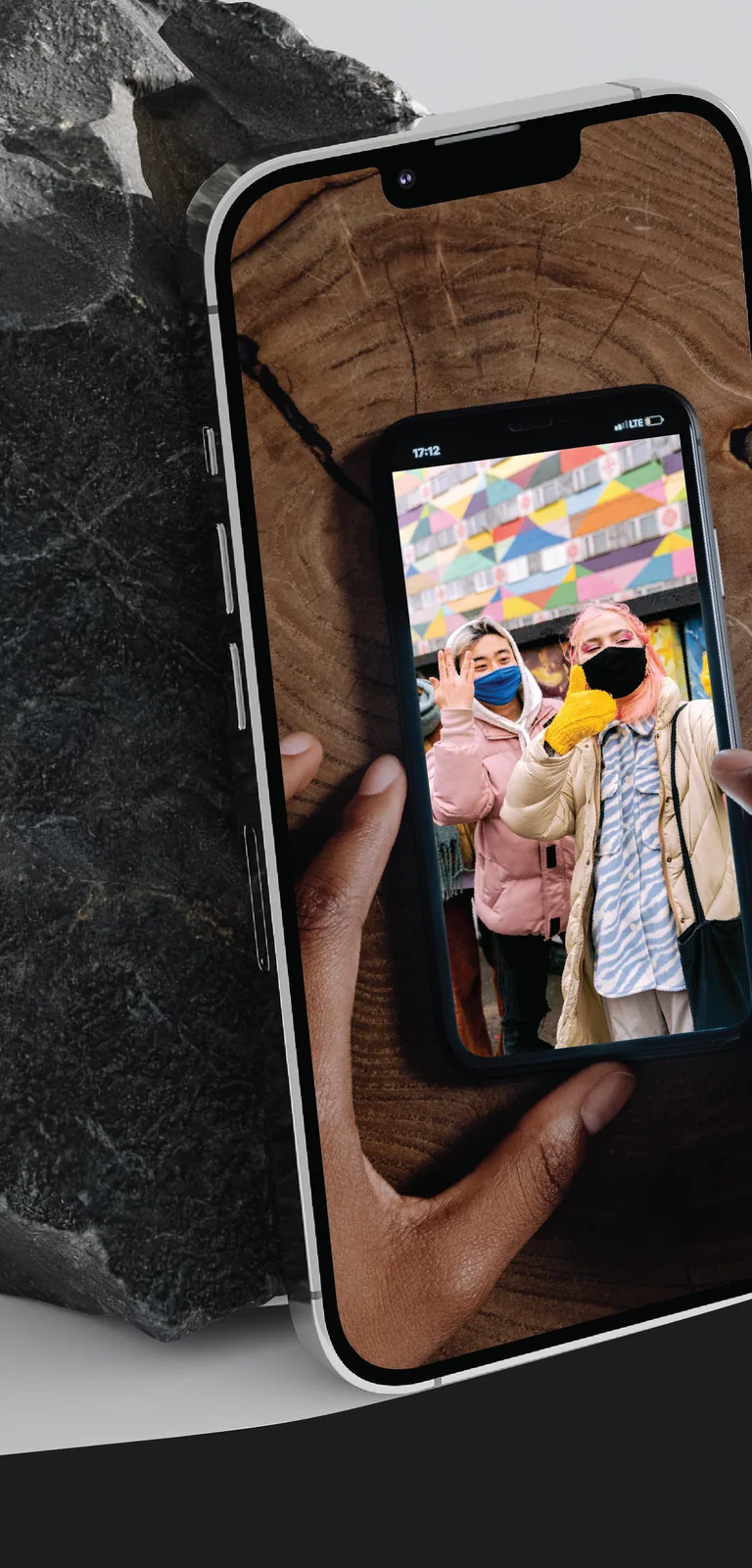 A cellphone photographing a cellphone photo of two women wearing masks, from the Cellphone: Unseen Connections exhibit