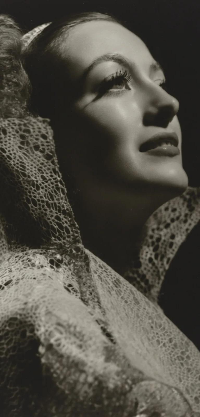 Black-and-white George Hurrell portrait of Joan Crawford, chin lifted, in dramatic studio lighting
