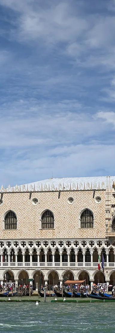 The Gothic facade of the Doge's Palace on the Venice waterfront with the campanile of St Mark's behind