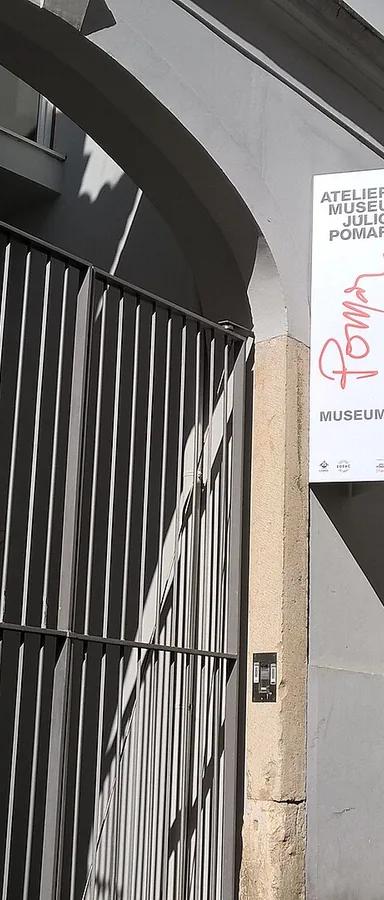 Whitewashed facade and gated entrance of the Atelier-Museu Júlio Pomar on Rua do Vale, Lisbon