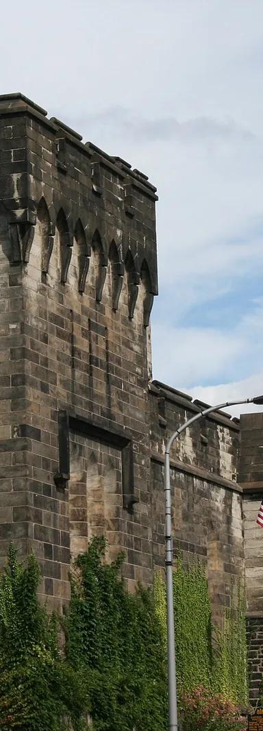 The castellated Gothic Revival main gate and stone perimeter wall of Eastern State Penitentiary on Fairmount Avenue, Philadelphia.