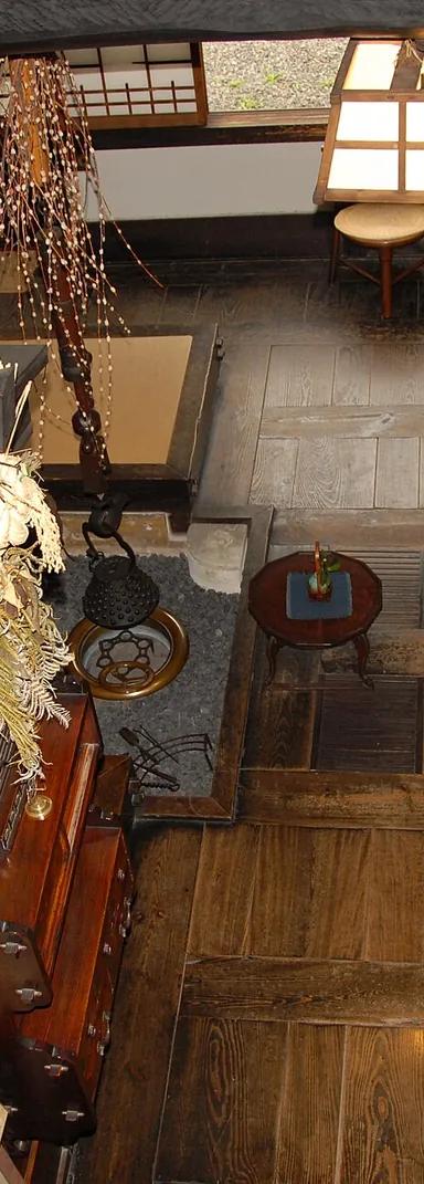 The wooden-floored main room of Kawai Kanjiro's House, Kyoto, with his chairs, hearth and hanging kettle hook