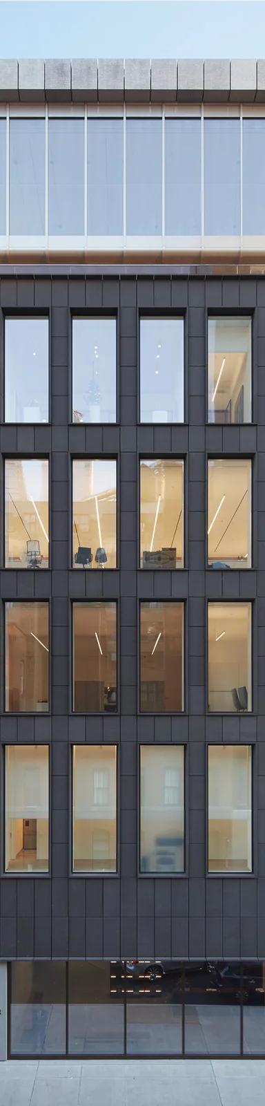 The Pace Gallery flagship at 540 West 25th Street, New York, an eight-story building clad in matte-black volcanic stone, at dusk