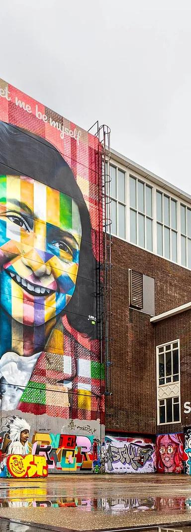 Exterior of STRAAT Museum's warehouse building at NDSM wharf, Amsterdam, with the Eduardo Kobra Anne Frank mural on its facade